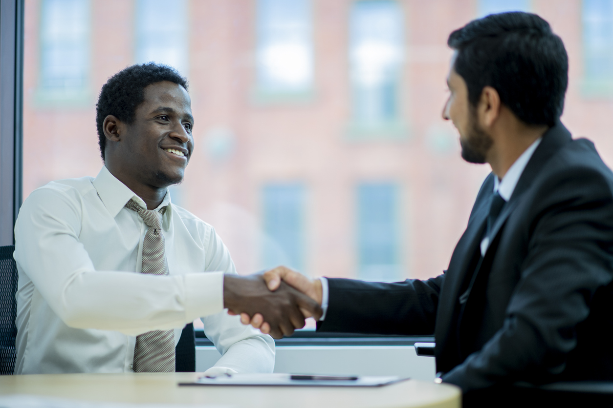 A human resources manager shakes hands with a job applicant.