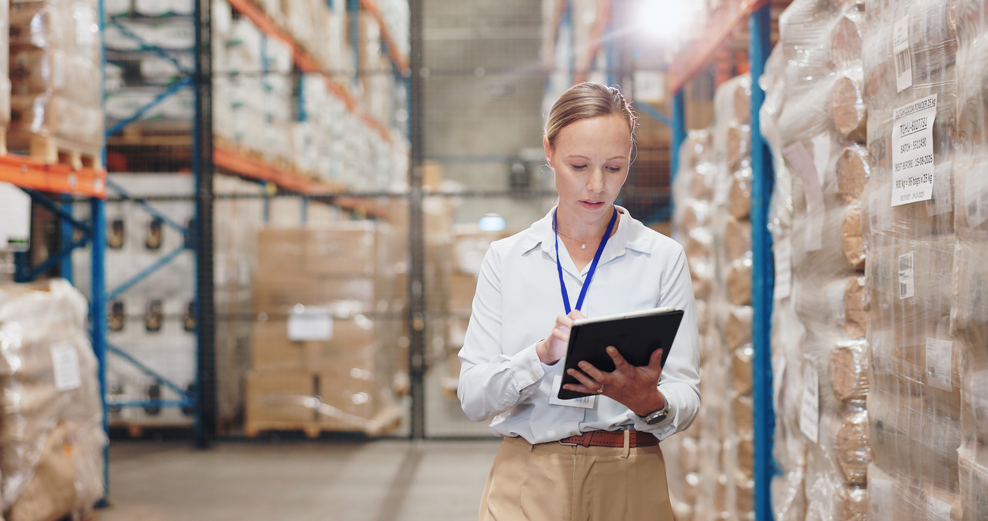 A supply manager checks inventory in a warehouse.